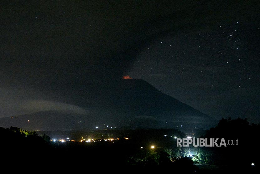 Gunung Agung menyemburkan asap dan abu vulkanis terlihat dari Desa Glumpang, Karangasem, Bali, Ahad (26/11) dini hari.
