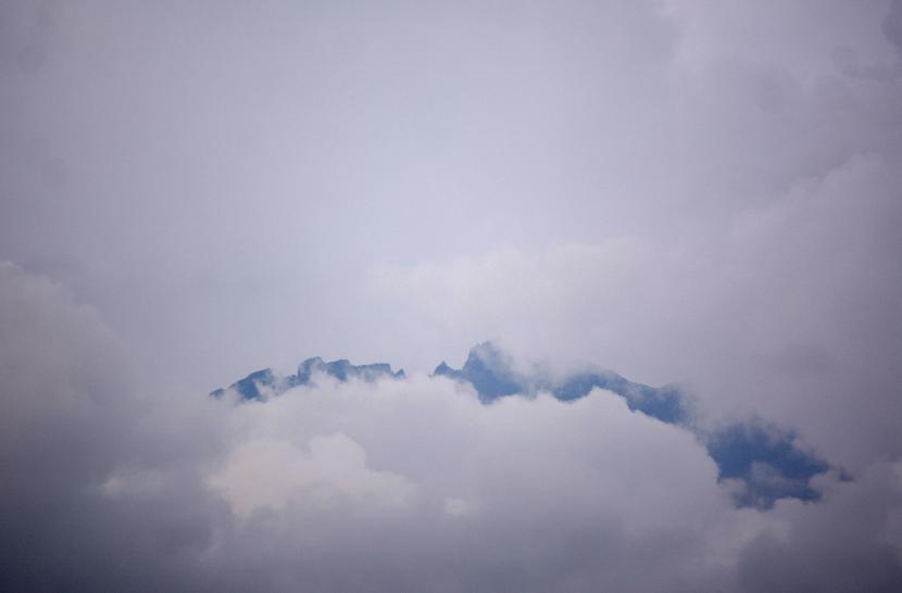 Gunung Raung tertutup awan terlihat dari Desa Garahan, Silo, Jember, Jawa Timur, Kamis (21/1/2021). Status Gunung Raung naik dari level I atau normal menjadi level II atau waspada karena mengalami erupsi kecil sejak Rabu (20/1).