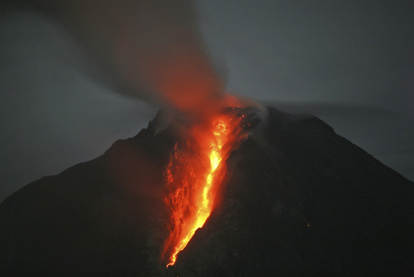   Gunung Sinabung memuntahkan lava panas seperti yang terlihat dari Desa Jeraya, Sumatera Utara, dalam foto yang diambil pada Ahad (5/1).   (AP/Binsar Bakkara)
