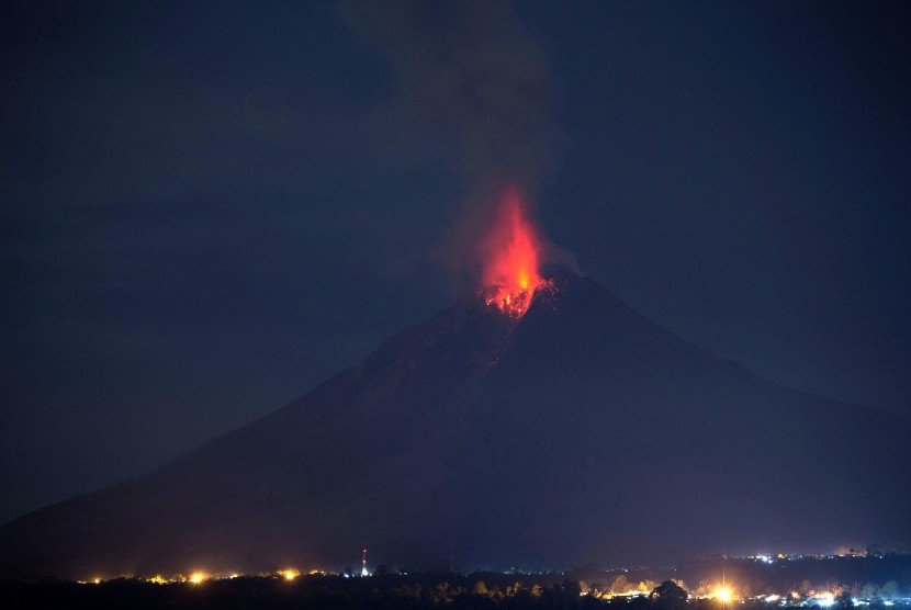 Gunung Sinabung memuntahkan lava pijar tampak dari Bukit Gundaling, Brastagi, Karo, Sumatera Utara, Jumat (18/12) dini hari.