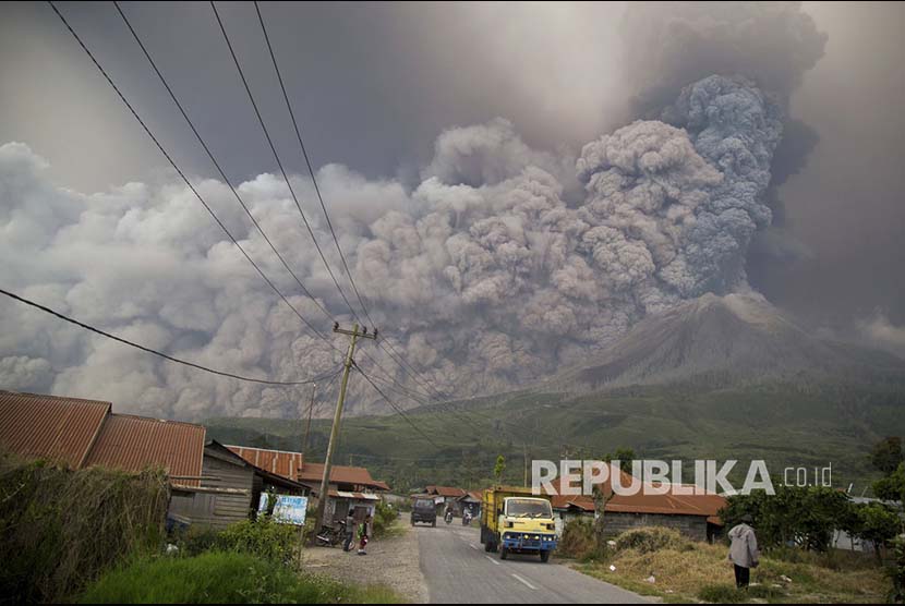 Gunung Sinabung memuntahkan materi  vulkanik tampak dari Kutarakyat, Sumatera Utara.