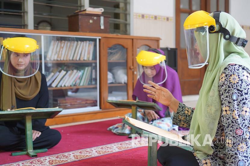 Pemkot Bogor Tambah Insentif Guru Mengaji pada 2021. Guru dan santri melakukan simulasi pembelajaran mengaji dengan alat pelindung diri berupa masker dan pelindung wajah transparan (face shield). Ilustrasi