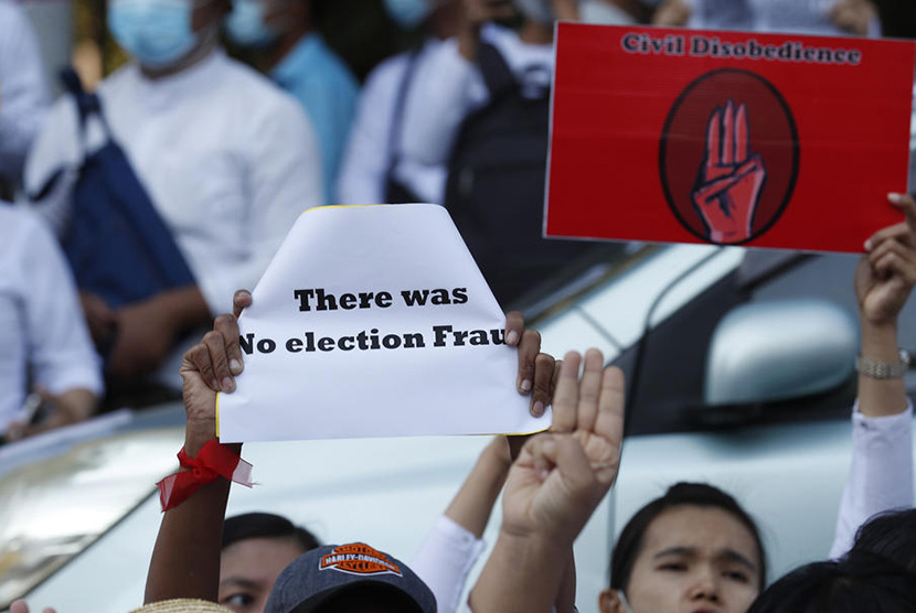 Guru-guru memegang poster tulisan dan simbol demo saat memrotes kudeta militer Myanmar. Mereka berunjuk rasa di depan Kedutaan Besar AS di Yangon, Myanmar, Rabu (10/2/2021). 