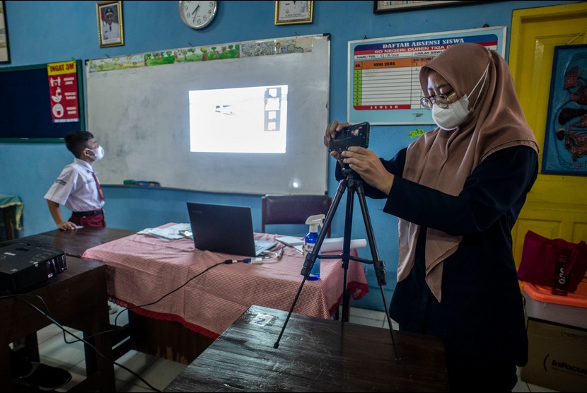 Guru Kelas IV, Isna (kanan) menyiapkan gawainya untuk pembelajaran sistem campuran (blended learning) di SDN Duren Tiga 09 Pagi, Jakarta, Selasa (8/2/2022). Dinas Pendidikan DKI Jakarta memberlakukan PTM 50 persen untuk sementara, seiring peningkatan kasus COVID-19 varian Omicron di Ibu Kota.