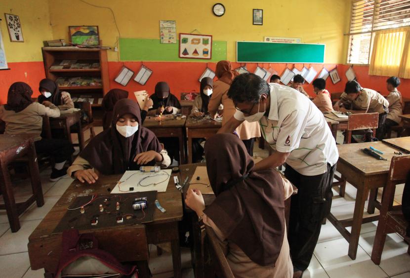Guru memberi arahan kepada seorang siswi saat mengikuti Pembelajaran Tatap Muka (PTM) SDN Pondok Pinang 01 , Jakarta , Rabu (23/3/2022). Sekjen Kemendikbud menegaskan vaksinasi Covid-19 bukan syarat masuk PTM.