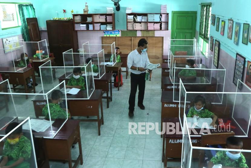 Guru memberikan pelajaran kepada muridnya di SDN 1 Lateng, Banyuwangi, Jawa Timur, Rabu (1/9). Badan Pusat Statistik mencatat kelompok pendidikan tercatat mengalami inflasi 1,2 persen