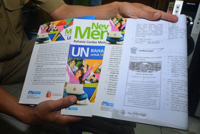 Guru memperlihatkan buku materi Ujian Nasional (UN) mata pelajaran Bahasa Inggris yang didalamnya terdapat gambar bermotif palu arit di SMA Negeri 1 Kawali, Kabupaten Ciamis, Jawa Barat, Senin (23/1). 