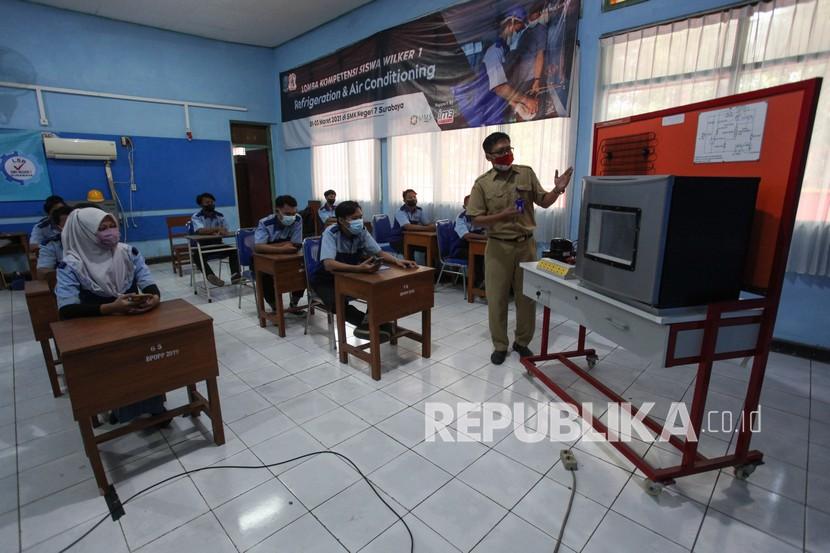 Guru mengajar muridnya di ruang kelas di SMK Negeri 7 Surabaya, Jawa Timur.
