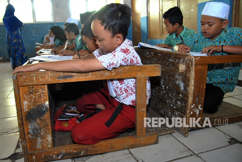 Guru mengajar sejumlah siswa SD Kelas 5 di kelas yang kekurangan meja dan bangku sekolah di SDN Kertajaya 02, Kampung Babakan RT 02/06, Desa Kertajaya, Rumpin, Kabupaten Bogor, Jawa Barat, Rabu (24/7/2019). 