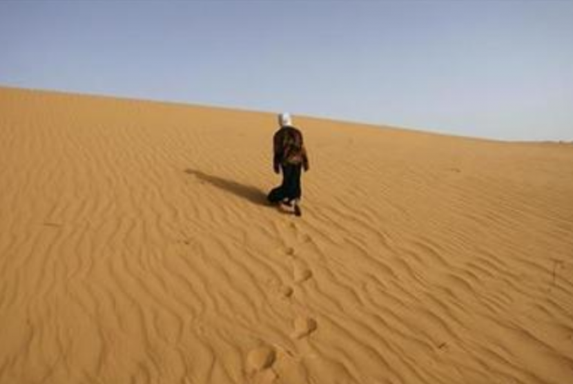 (ilustrasi) seseorang berjalan di atas gurun.