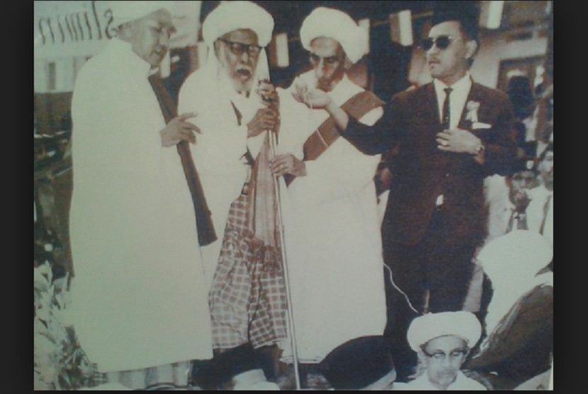 Habib Husein Shihab (memakai jas) saat menghadiri Maulid Nabi di Majelis Habib Kwitang