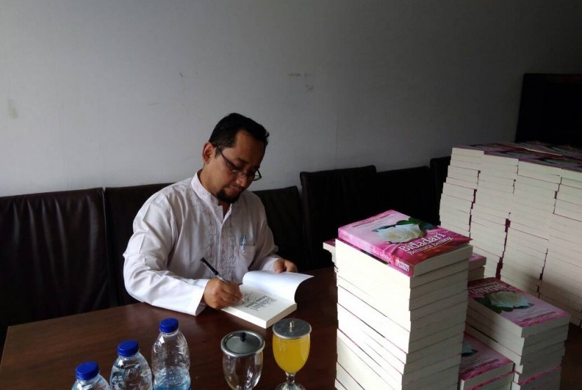 Habiburrahman El Shirazy menandatangani novel Bidadari Bermata Bening yang dibeli melalui pemesanan pre order, Ahad (30/4).
