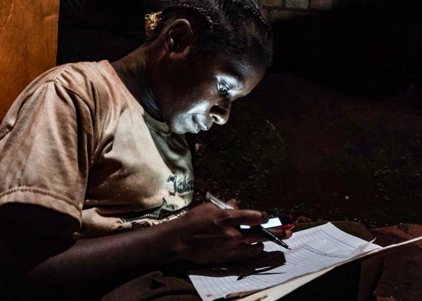 Hagar Kegiye (12 tahun) mengerjakan tugas sekolah di kios layanan internet, Kota Jayapura, Papua. PJJ yang dipandang tidak efektif bagi mayoritas siswa di Indonesia mendorong pembukaan kembali sekolah secara tatap muka di zona hijau dan kuning.