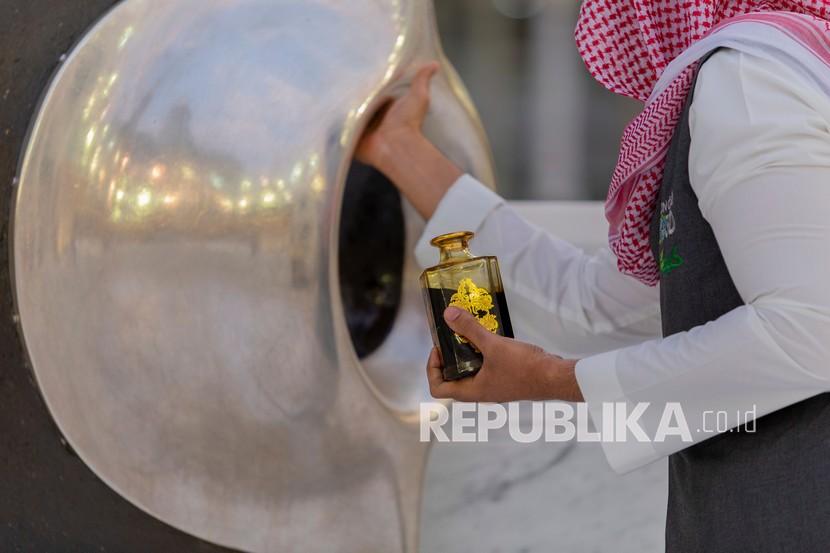 Seorang petugas memberi wewangian untuk Hajar Aswad yang terletak di sudut timur Kabah di Makkah, Arab Saudi, Senin (27/7/2020). Kegembiraan Jamaah Bisa Menyentuh Kembali Hajar Aswad