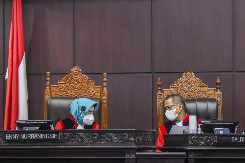 Hakim Konstitusi Enny Nurbaningsih (kiri) berbincang dengan Hakim Konstitusi Saldi Isra di sela-sela sidang uji materiil Undang-Undang Nomor 7 Tahun 2017 tentang Pemilihan Umum di Gedung Mahkamah Konsitusi, Jakarta, Rabu (31/8/2022).