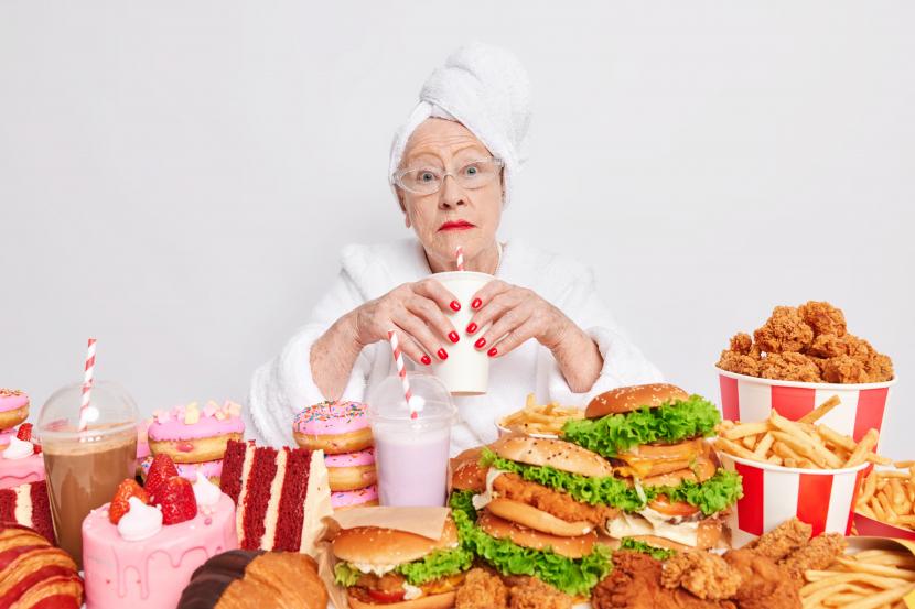 Menyantap junk food (ilustrasi). Ada kebiasaan-kebiasaan makan yang perlu dihindari ketika seseorang sudah memasuki usia 50 tahun.