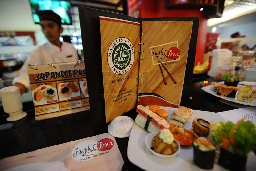   Pekerja sedang menyajikan makanan di restoran siap saji Sushi Bar yang baru meraih sertifikasi halal dari LPPOM MUI