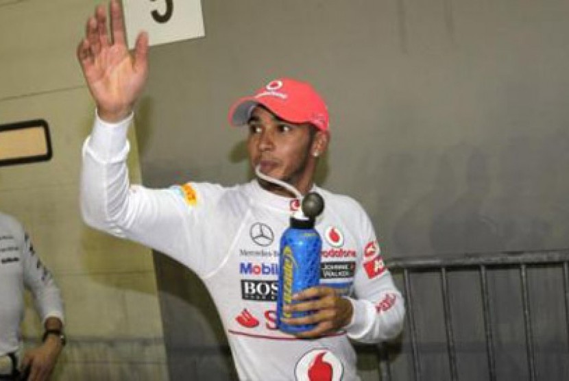 Hamilton melambaikan tangan di Sirkuit Marina Bay, Singapura setelah berhasil mengamankan posisi start terdepan 