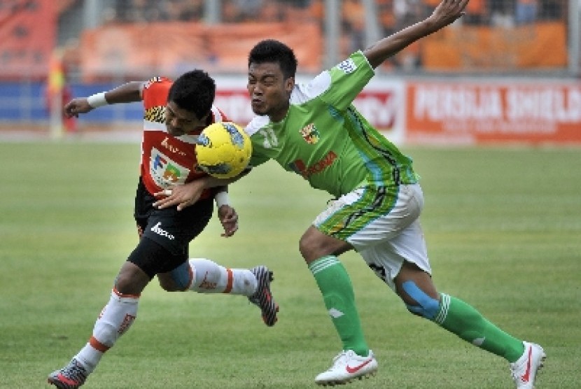 Hamka Hamzah saat berebut bola dengan Bambang Pamungkas.