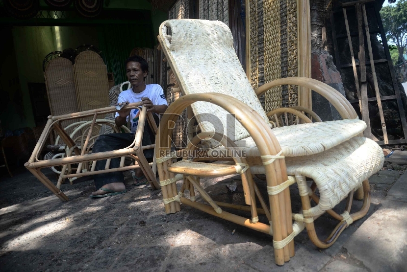 Harga Rotan Beranjak Naik: Pengrajin menghaluskan kursi yang terbuat dari rotan di bengkel rotan, Jakarta, Rabu (18/3). 