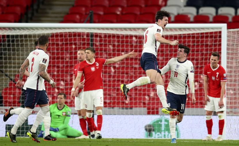 Harry Maguire dari Inggris (tengah) merayakan gol kedua timnya selama pertandingan sepak bola kualifikasi grup I Piala Dunia 2022 antara Inggris dan Polandia di stadion Wembley di London, Inggris, Kamis (1/4).