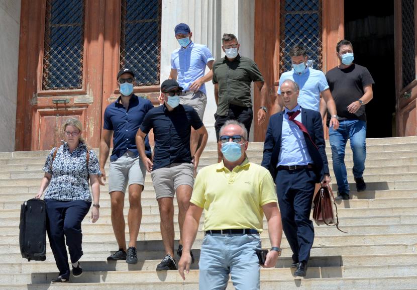 Harry Maguire (kiri atas) bersama rekan-rekan dan tim kuasa hukumnya meninggalkan gedung pengadilan di Syros, Yunani, Ahad (23/8).