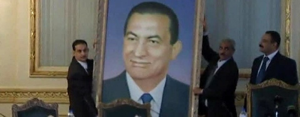 Petugas menurunkan foto Hosni Mubarak di Gedung Kabinet, di Kairo, Februari lalu.