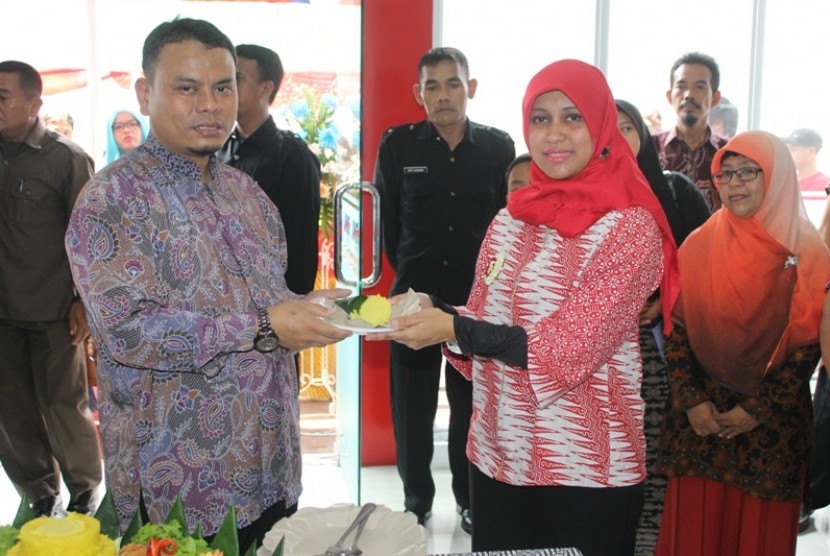 Head of Regional Jabar JNE Hardiana Apriliyanti (kanan) menyerahkan potongan tumpeng kepala Branch Manager JNE Karawang Syamsuri sebagai tanda peresmian Kantor Perwakilan JNE Karawang Barang, belum lama ini.