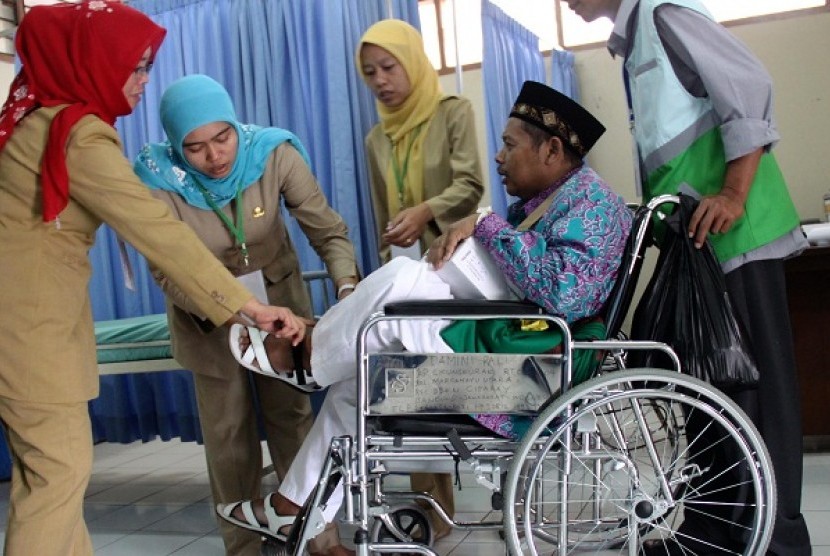 Health workers examine a hajj pilgrim (sitting in wheel chair) in Bekasi, West Java, on Wednesday, September 11, 2013.