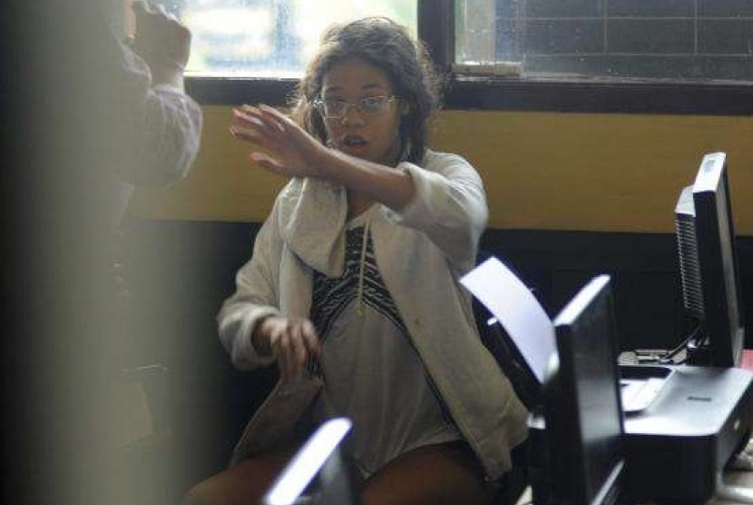 Heather Mack, the daughter of an American woman found dead inside a suitcase on the Indonesian holiday island of Bali, gestures while in custody in a police station in Denpasar August 14, 2014.