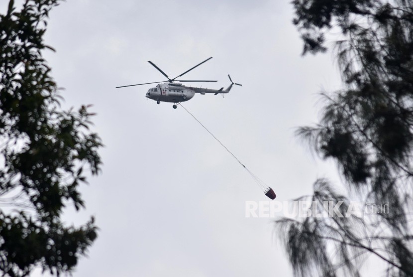 Helikoper tipe MI 8 EY-225 milik Badan Nasional Penanggulangan Bencana (BNPB) terbang dengan membawa wadah air usai melakukan pemadamam kebakaran di Taman Nasional Gunung Merbabu (TNGM), Thekelan, Getasan, Kabupaten Semarang, Jawa Tengah, Rabu (17/10/2018).