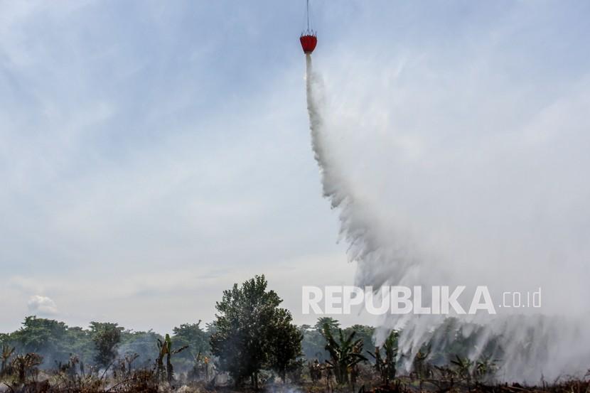 Helikopter Badan Nasional Penanggulangan Bencana (BNPB) melakukan water bombing diatas lahan gambut yang terbakar di Desa Teluk Kenidai, Kabupaten Kampar, Riau, Kamis (7/10/2021). Badan Meteorologi Klimatologi dan Geofisika (BMKG) Stasiun Pekanbaru mendeteksi adanya peningkatan titik panas (hotspot) pada Kamis (7/10) di wilayah Sumatera sebanyak 154 titik, diantaranya tersebar di Aceh 1 titik, Sumatera Utara 23, Sumatera Barat 35, Sumatera Selatan 8, Jambi 8, Kepulauan Riau 3, Bangka Belitung 13, Bengkulu 1, Lampung 10 dan Riau sebanyak 52 titik panas. 