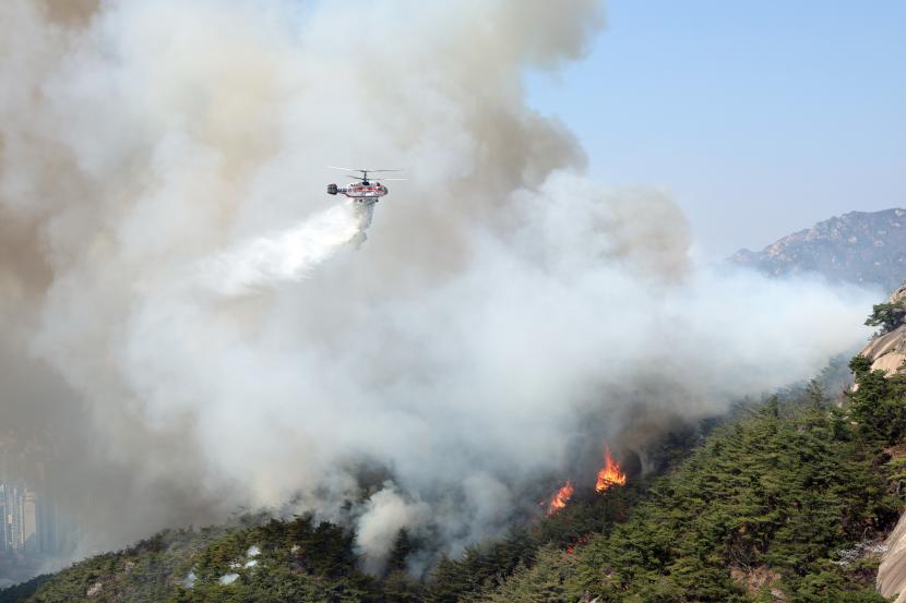 Helikopter Badan Pemadam Kebakaran Nasional membuang air untuk menahan api yang membakar di Gunung Inwang, Seoul, Korea Selatan, 02 April 2023.