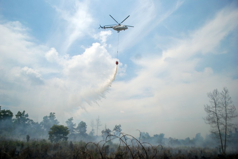 Helikopter BNPB jenis MI-8 melakukan pemadaman dari udara di atas lahan yang terbakar di Pekanbaru, Riau, 10 Agustus 2016. 