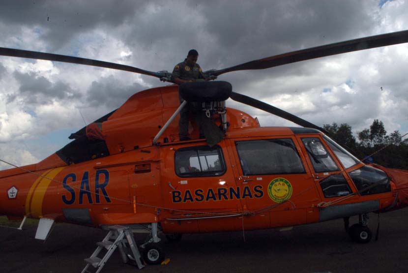 Helikopter jenis Dolphin milik Basarnas ditutupi terpal oleh petugas di posko utama Lanud TNI AU Iskandar, Pangkalan Bun, Kotawaringin Barat, Kalimantan Tengah, Rabu (28/1).  (Republika/Rusdy Nurdianysah)