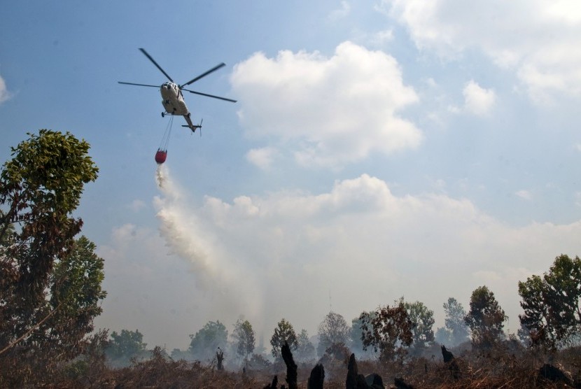  Helikopter MI 17 dari Badan Nasional Penanggulangan Bencana (BNPB) menjatuhkan bom air di atas lahan yang terbakar di Kecamatan Payung Sekaki, Kota Pekanbaru, Riau, Jumat (24/7).