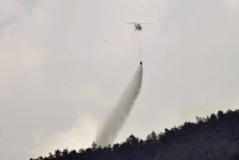 Helikopter Water Bombing  MI 8 milik BNPB memadamkan titik api dari udara, di wilayah Dusun Ngaduman, Desa Batur, Kecamatan Getasan, Kabupaten Semarang, Rabu (17/10). Upaya pemadaman api yang membakar hutan kawasan lereng Merbabu mulai mendapatkan dukungan dari udara.
