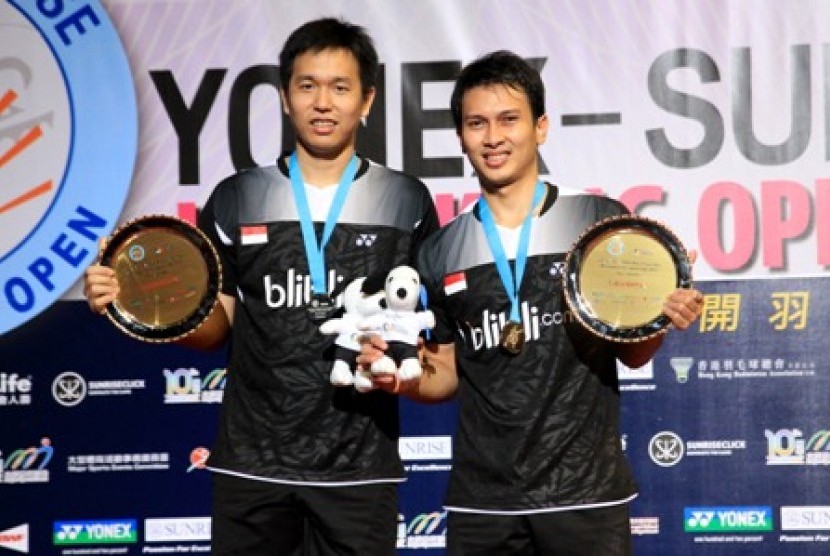 Hendra Setiawan (kiri) dan Mohammad Ahsan berpose dengan trofi juara Hong Kong Open Super Series, Ahad (23/11).