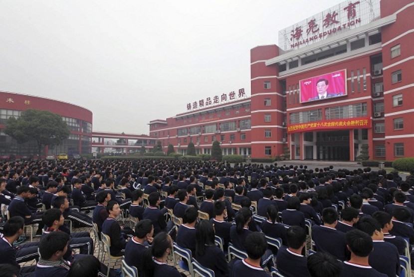 High school students watch a screen showing Hu Jintao, general secretary of the Central Committee of the Communist Party of China (CPC) and Chinese president, delivering a keynote report during the opening ceremony of the 18th National Congress of the Comm