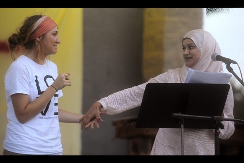 Hina Qidwai (berjilbab) berterima kasih kepada mahasiswa OCC, Ashley Carter (kiri) yang mengorganisir unjuk rasa cinta untuk Masjid Joplin di Taman Landreth, Sabtu.