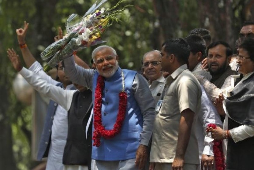 Hindu nationalist Narendra Modi (wearing a garland), the prime ministerial candidate for India's Bharatiya Janata Party (BJP), gestures to his supporters outside party's headquarters in New Delhi May 17, 2014.