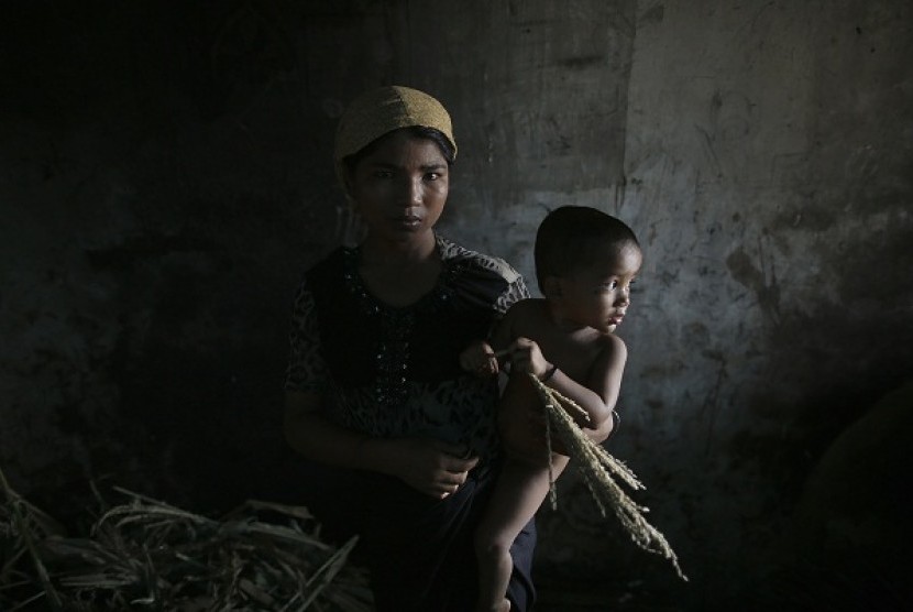 Hla Hla May, a Rohingya Muslim woman displaced by violence, holds her one year old daughter Roshan at a former rubber factory that now serves as their shelter, near Sittwe April 29, 2013. 