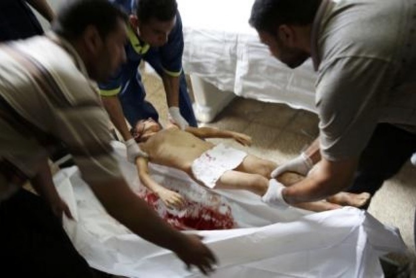 Hospital workers prepare the body of Osama Al-Astal (6years) killed in his home along with three other family members by an Israeli air strike before a five-hour humanitarian truce, in Gaza Strip, July 17, 2014. 