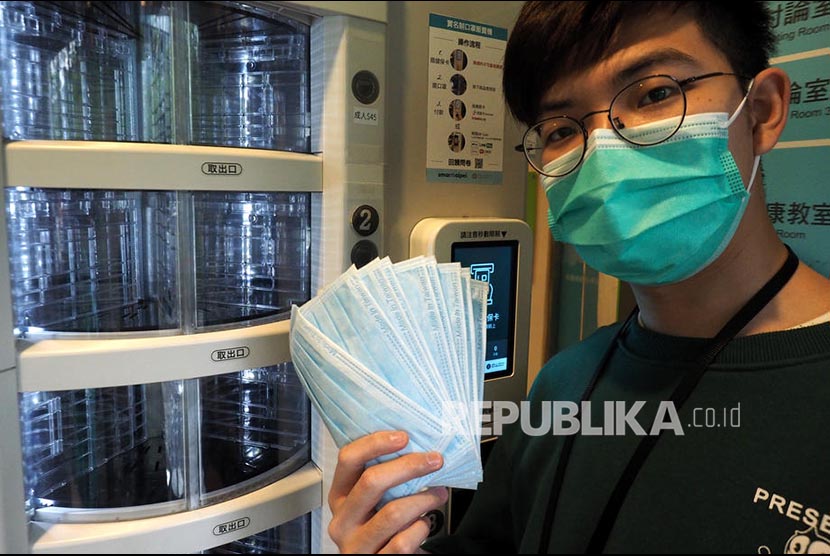 Hsu Han-ping menunjukkan masker yang dibelinya dari mesin penjual otomatis di Taiwan, Ahad (12/4).  Pemerintah setempat memberikan jatah pembelian 9 buah masker bagi warganya setiap dua minggu.