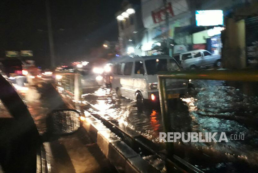  Hujan deras menyebabkan genangan air di turunan fly over Jalan Arif Rahman Hakim Depok, Senin (10/4).