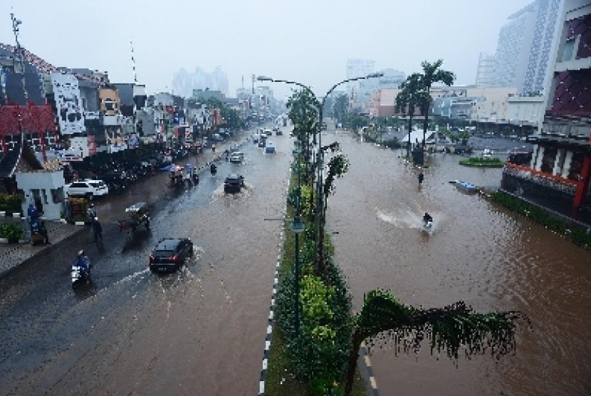 Hujan menimbulkan banjir di kawasan Boulevard Kelapa Gading, Jakarta Utara, Jumat (23/1). 