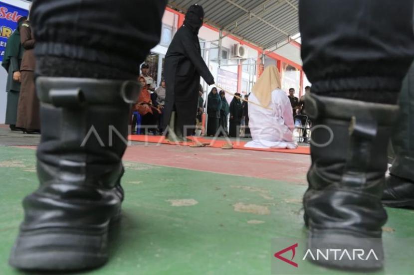 Terpidana pelanggar peraturan daerah (qanun) Syariat Islam (tengah) menjalani proses eksekusi hukuman cambuk di perkarangan Lembaga Pemasyarakatan kelas II B Meulaboh, Aceh Barat, Aceh, Kamis
