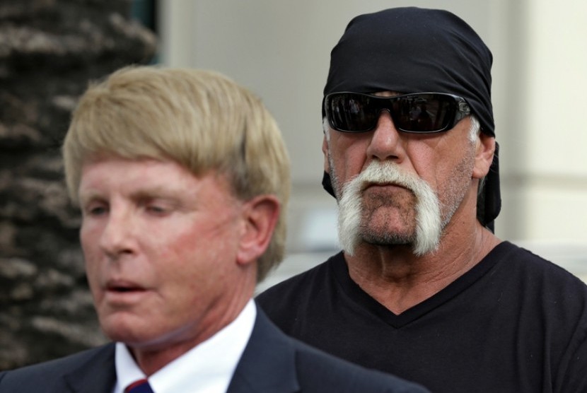 Hulk Hogan yang memiliki nama asli Terry Bollea berdiri di belakang pengacaranya, David Houston, yang tengah berbicara pada wartawan terkait peredaran video porno Hulk Hogan. 