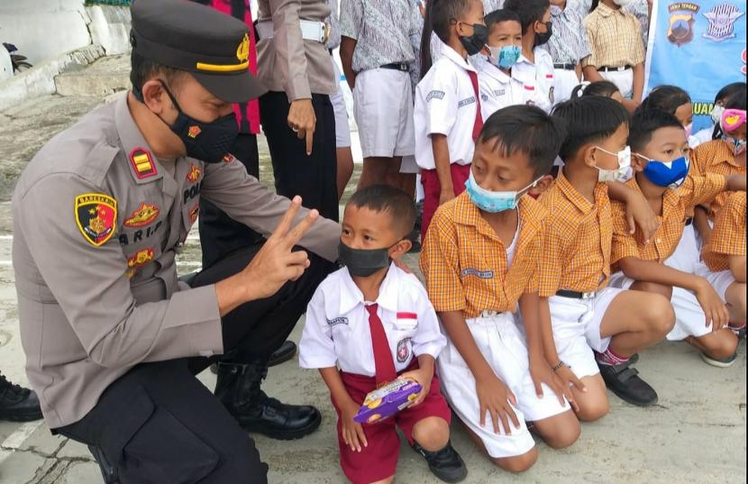 Seorang personel Polsek Bandungan, Kabupaten Semarang (kiri) terlihat menghibur anak yang akan menjalani vaksinasi.