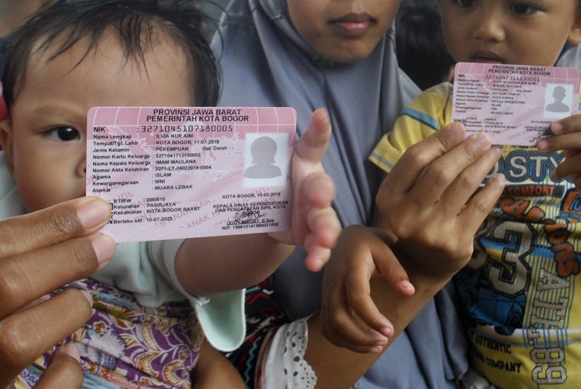 Ibu bersama anaknya menunjukkan Kartu Identitas Anak (KIA) saat Hari Tanpa Kendaraan Bermotor di kawasan Sudirman, Kota Bogor, Jawa Barat, Ahad (10/3/2019).